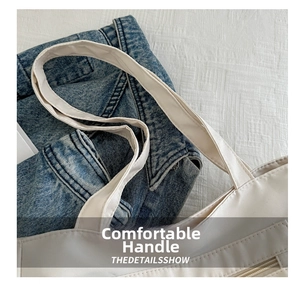 Detail shot of white canvas tote bag handles and front zipper pocket on denim