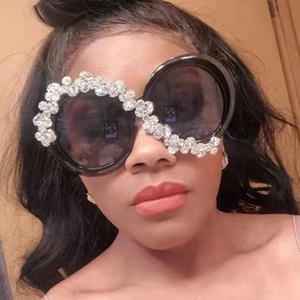 Detailed close-up of oversized round sunglasses with sparkling rhinestone embellishments