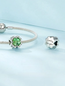 Macro shot of S925 silver four-leaf clover charm with green gemstone and Lucky for you engraving