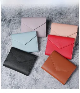 Dreifach gefaltete Umschlag-Brieftaschen mit Litschi-Muster in mehreren Farben auf Blau