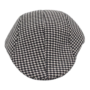 Macro shot of black and white houndstooth pattern fabric on a classic flat cap for men
