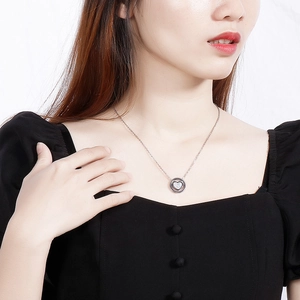 Collier élégant en argent avec pendentif coeur en nacre porté par un mannequin femme
