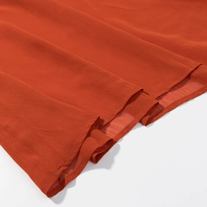 Close-up of bright orange pleated chiffon fabric with high-quality hem stitching details