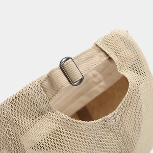 Close-up of adjustable metal buckle and breathable mesh fabric on beige newsboy cap