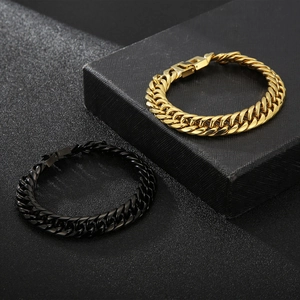 Detail of interlocking gold and black Cuban chain bracelets with secure lobster clasps