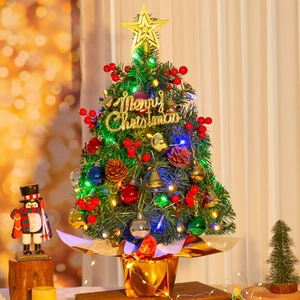 Detailed view of mini Christmas tree with warm LED lights and colorful ornaments decoration