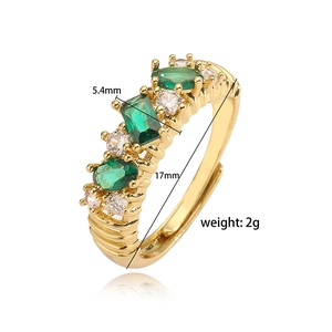 Detailed view of adjustable gold ring with green emerald cut stones and 17mm inner diameter