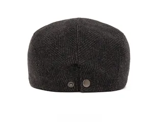 Rear view of dark grey herringbone newsboy hat with a metal buckle detail