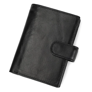 Detail view of the black leather wallet with snap button strap and neat stitching texture