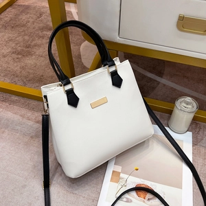 Detail view of the black and white contrast leather handbag on a modern display stand