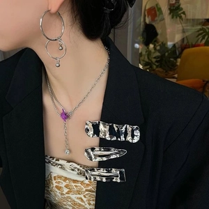 Close-up of stylish silver hair clips with minimalist wave and teardrop metal designs