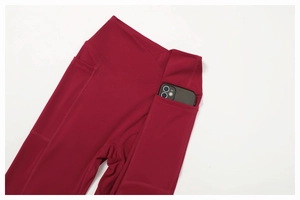 Detail of high-waisted burgundy yoga pants featuring a functional side phone pocket