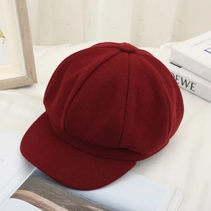 Close-up of red wool octagonal newsboy hat showing thick fabric texture and brim