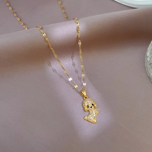 Detailed view of a gold-plated dog pendant with micro-paved diamonds on soft silk
