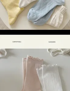 Detailed view of white cotton socks with cute ruffled edges and ribbed texture