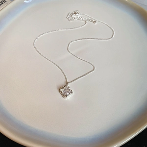 Close-up of 18k gold plated hollow square zircon pendant on a silver-tone necklace