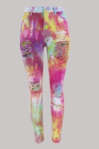 Detail of multi-colored tie-dye denim jeans with high-waisted distressed ripped design