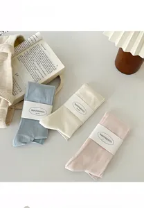 Detail view of pink, blue, and cream knit calf socks with seamless traceless process