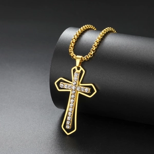 Detailed macro view of a gold cross pendant with cubic zirconia on black background