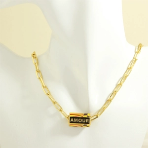 Detail of gold evil eye necklace with AMOUR engraving on model for chic hip-hop style