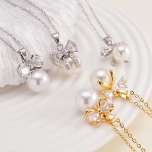 Elegant bow knot necklace with pearl and zircon pendant in gold and silver finishes