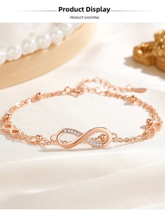 Detailed close-up of rose gold infinity bracelet with micro-pave crystals on silk