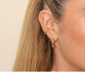 Close-up of gold s925 silver hoop earrings and ear cuffs on model with zircon detail