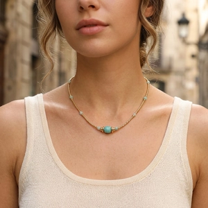 Detail of Amazonite beaded necklace with gold chain worn on model in a street setting
