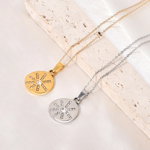 Detailed view of gold and silver hexagram sunburst zircon pendants on stone