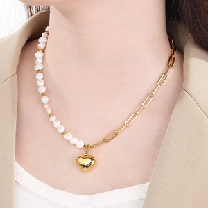 Détail d'un collier en perles et chaîne dorée avec pendentif cœur sur un modèle