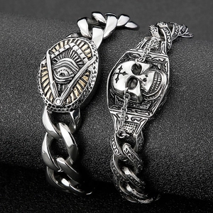 Macro view of gothic skull and all-seeing eye charms on chunky stainless steel chain