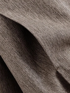 Macro shot of brown herringbone wool fabric texture on a casual bomber jacket