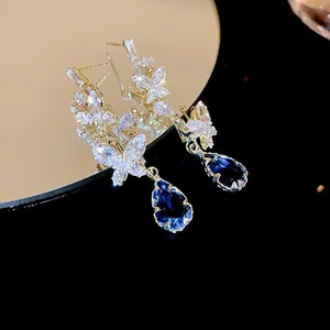 Detail of butterfly tassel earrings with blue pear-cut gemstone and cubic zirconia