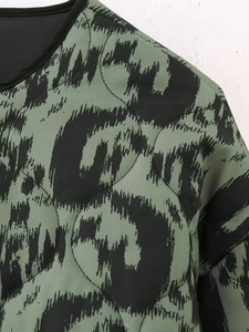 Detail of green and black vintage printed quilted jacket with diamond stitch patterns