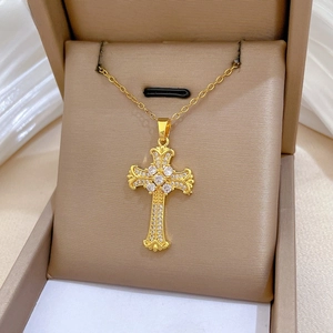 Dettaglio della collana in acciaio al titanio dorato con ciondolo a croce e cristalli lucidi