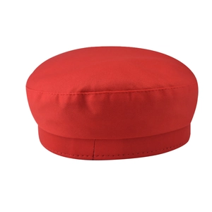 Détail latéral d'un béret rouge en cuir PU à sommet plat montrant les coutures et la texture