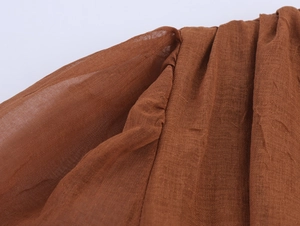 Detail of brown v-neck dress showing pleated texture and breathable cotton-linen fabric