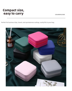 Stack of colorful PU leather mini jewelry boxes with zippers on green velvet fabric