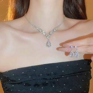 Detailed view of teardrop zircon necklace and earrings set worn by a fashion model