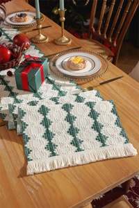 Detail of red and green cotton table runner featuring festive tassels and geometric patterns