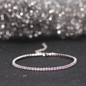 Macro shot of silver tennis bracelet with pink cubic zirconia and adjustable chain
