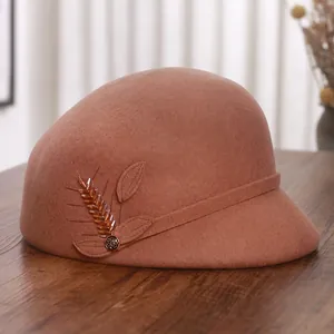 Elegant camel wool cloche hat with crystal wheat spike decor on a vintage wood surface