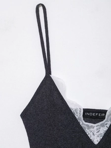 Détail d'un caraco en maille gris foncé avec bordure et coutures en dentelle blanche