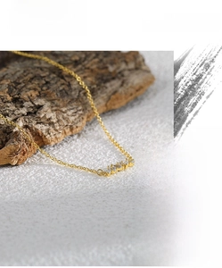 Macro shot of sparkling marquise cubic zirconia pendant on a gold cable chain