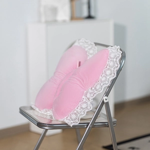 Detail of pink butterfly plush pillow with white lace trim on a silver chair