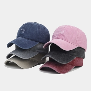 Detail showing various colors of washed cotton baseball caps with small puppy embroidery
