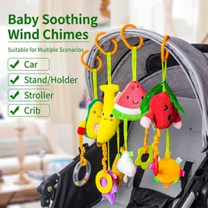 Close-up of fruit-shaped plush stroller toy with hanging banana and strawberry charms