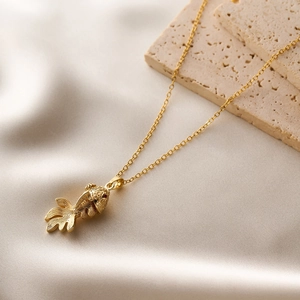 Detailed close-up of a high-quality gold carp fish pendant with a thin necklace chain