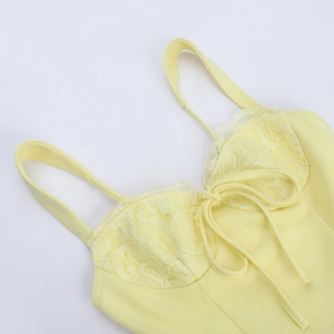Détail de l'encolure en dentelle jaune et du cordon de serrage sur la robe d'été