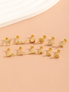 Detailed grid of 12 gold plated nose rings with butterfly, moon and star charms